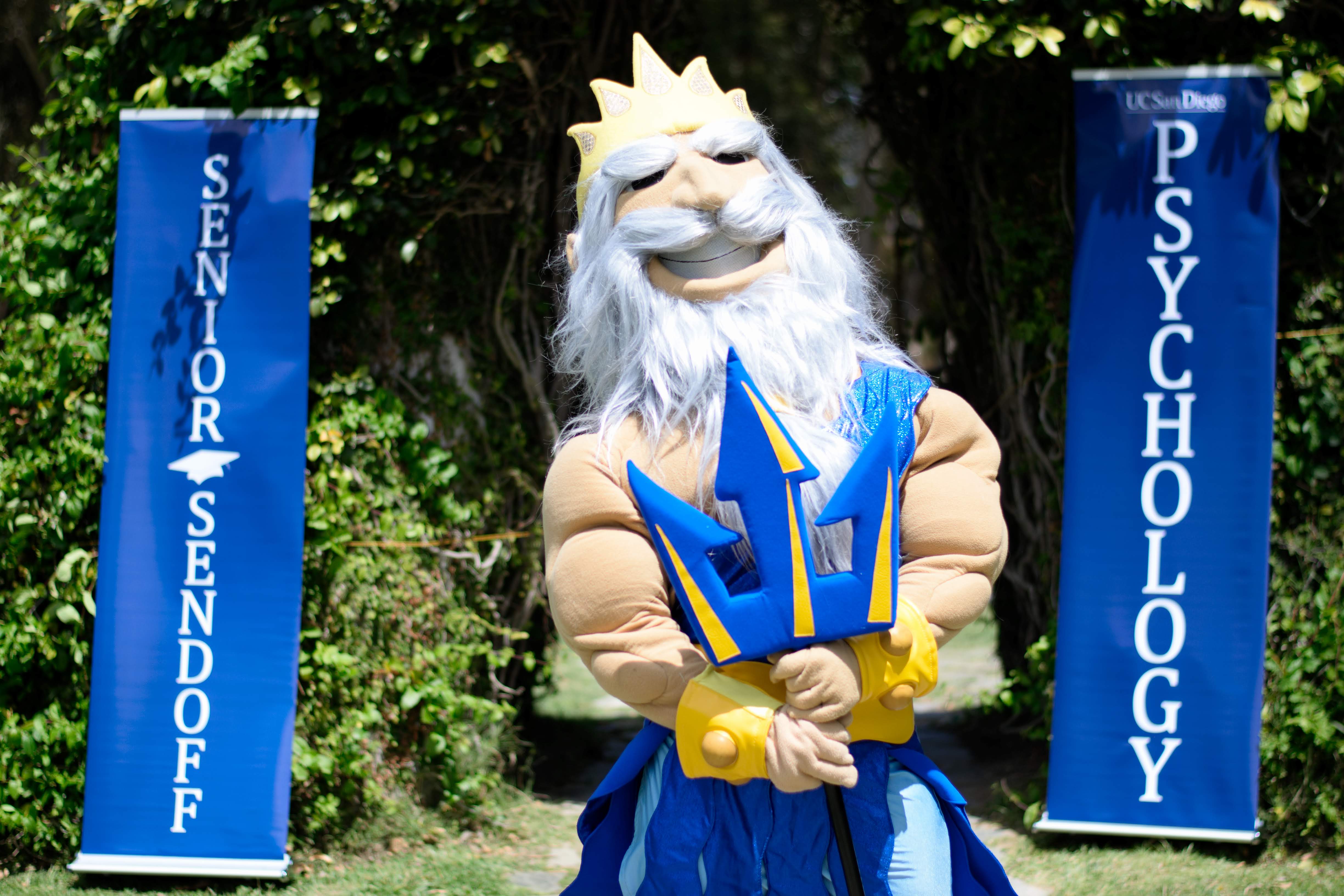 King Triton poses in front of the Sun God statue