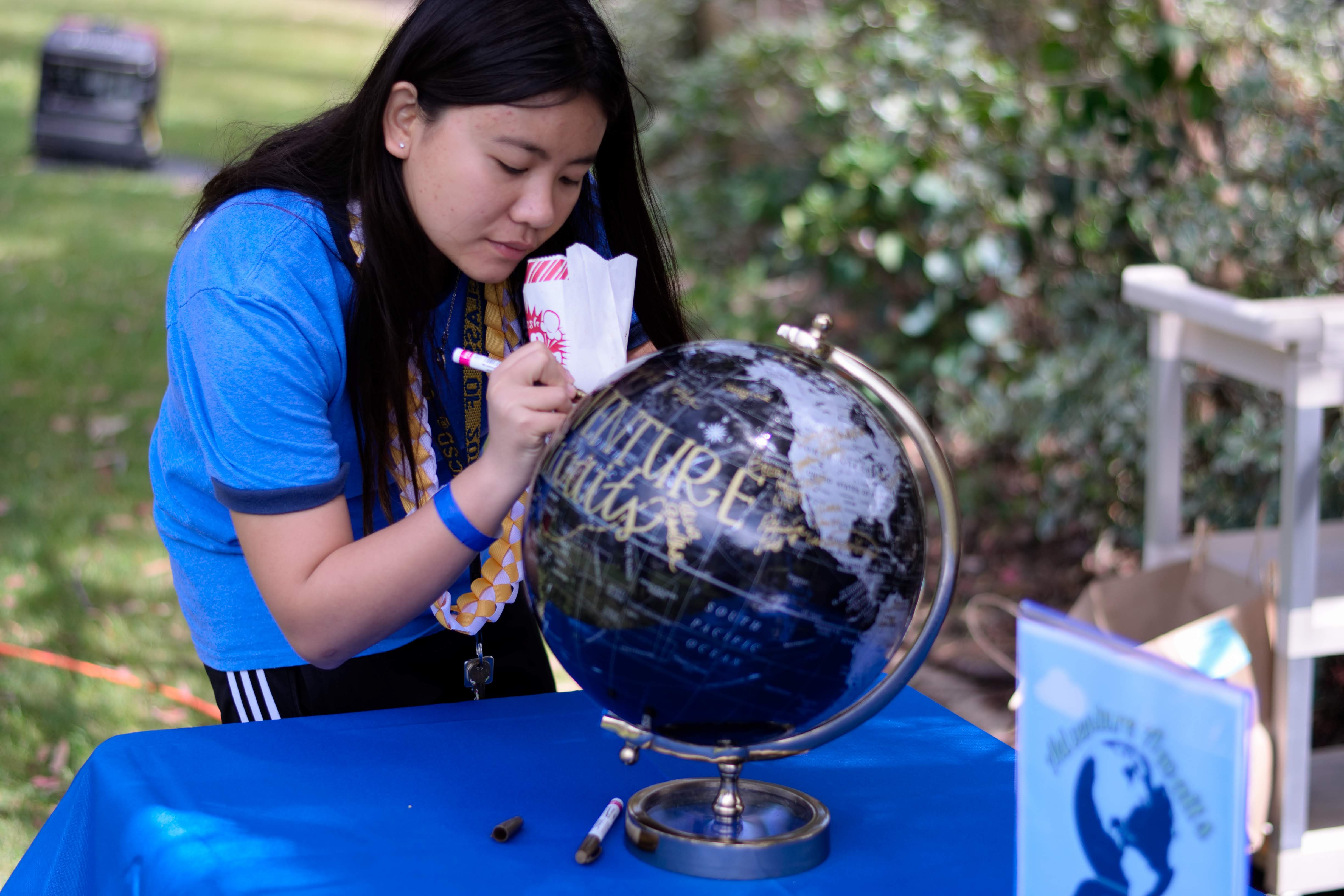 A student signs a globe at Senior Send-Off 2019